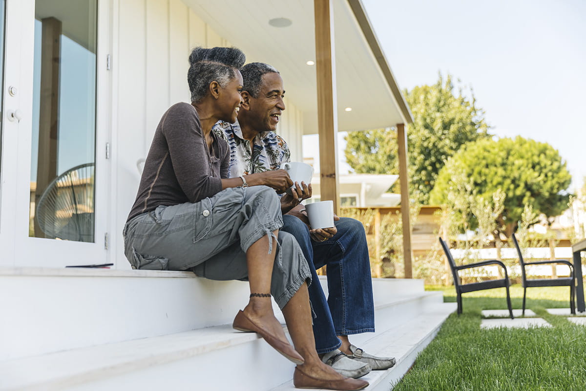 Couple having coffee on their porch.