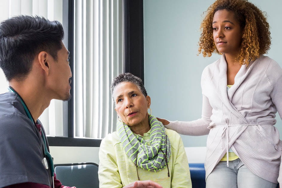 Younger male doctor talking with female patient and her daughter general cardiology care